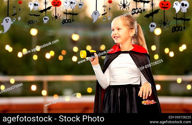 girl in halloween costume of dracula with candies