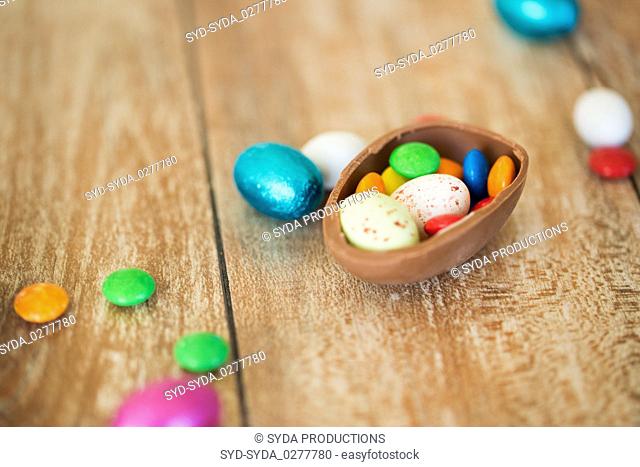 chocolate easter egg and candy drops on table