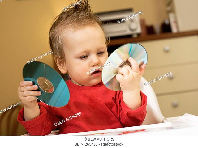 Baby playing with compact discs