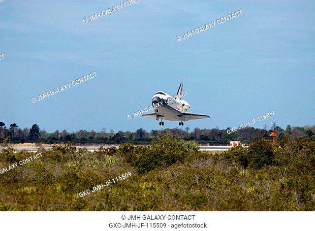 Space shuttle Discovery glides above Runway 15 before touching down at the Shuttle Landing Facility at NASA's Kennedy Space Center in Florida