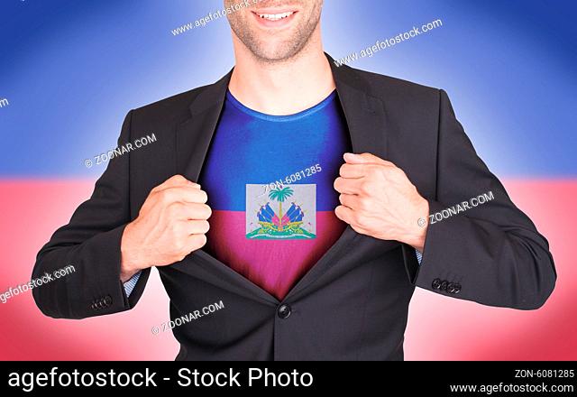 Businessman opening suit to reveal shirt with flag, Haiti