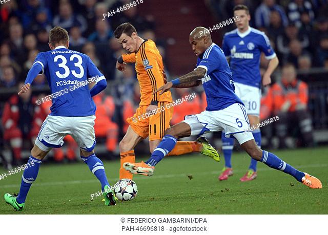 Madrid's Gareth Bale (C) scores a 0-2 goal past Schalke's Felipe Santana (R) and Roman Neustaedter (L) during the Champions League round of sixteen match...