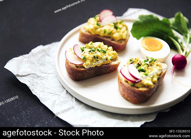 Bread with egg salad, garnished with radishes and chives