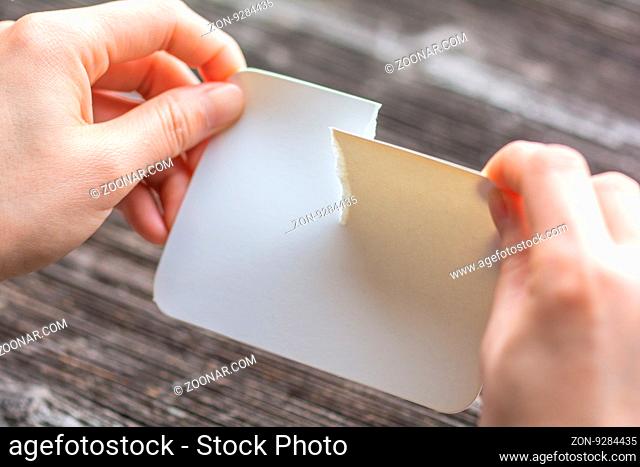 woman tearing the white paper