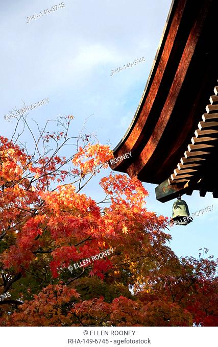 Bright orange acer leaves next to a bell and the wooden roof of the Hida Kakubun-ji Pagoda in Takayama, Japan, Asia