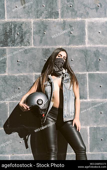 Portrait of sexy young woman posing with motorcycle helmet