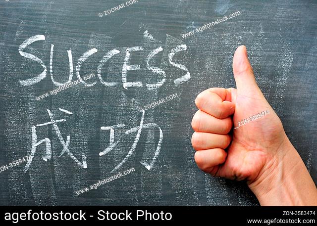 Success - word written with chalk on a blackboard with a Chinese translation