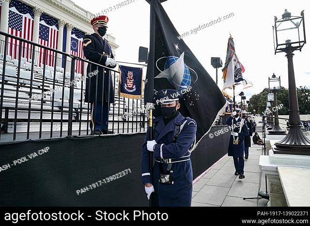 A member of the Air Force holds a Space Force flag in an honor guard during a dress rehearsal for the 59th inaugural ceremony for President-elect Joe Biden and...