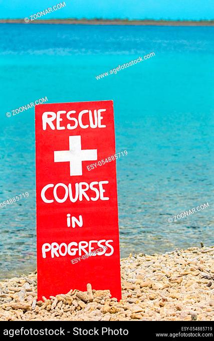 Red warning sign for rescue exercise on beach by the sea