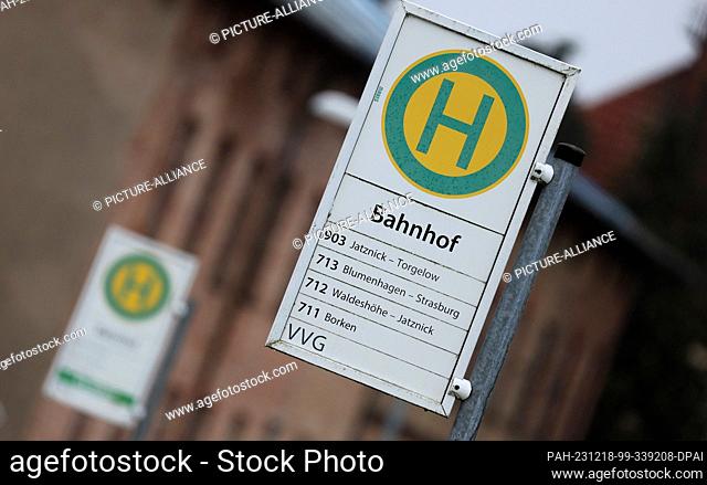 PRODUCTION - 18 December 2023, Mecklenburg-Western Pomerania, Schwerin: Signs at the bus stops in front of the train station