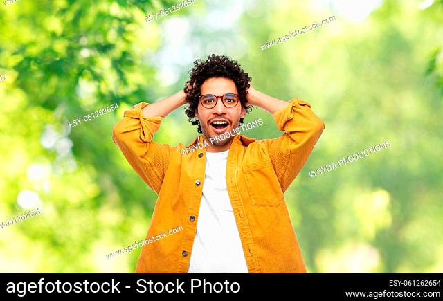 happy man holding to head on natural background