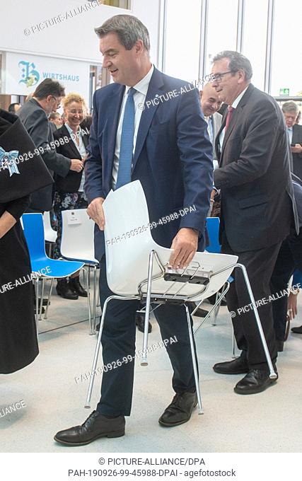 26 September 2019, Bavaria, Regensburg: Markus Söder (CSU), Prime Minister of Bavaria, is wearing a chair after the opening ceremony of the state exhibition...