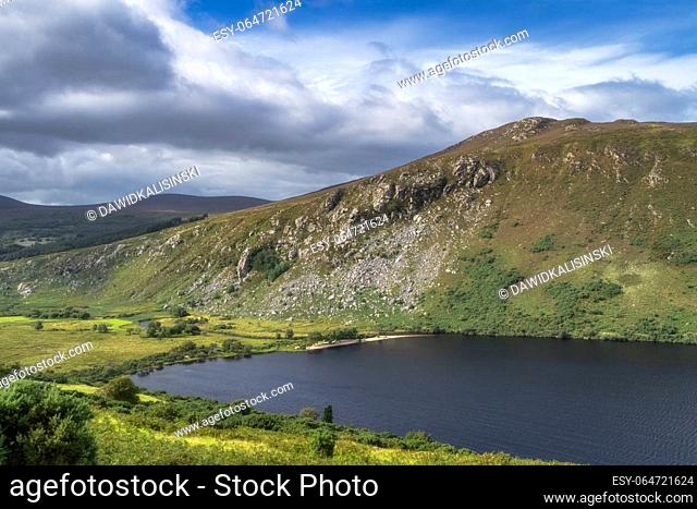 Beautiful panorama with lake, beach, forest, valley and rocky steep mountain. Lough Dan in Wicklow Mountains, Ireland