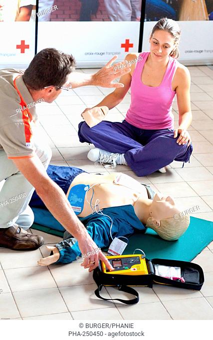 First aid training courses given by the French Red Cross. Portable semi-automatic heart defibrillator used on a mannequin