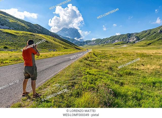 Italy, Abruzzo, Gran Sasso e Monti della Laga National Park, Photographer shooting plateau Campo Imperatore and Corno Grande mountain