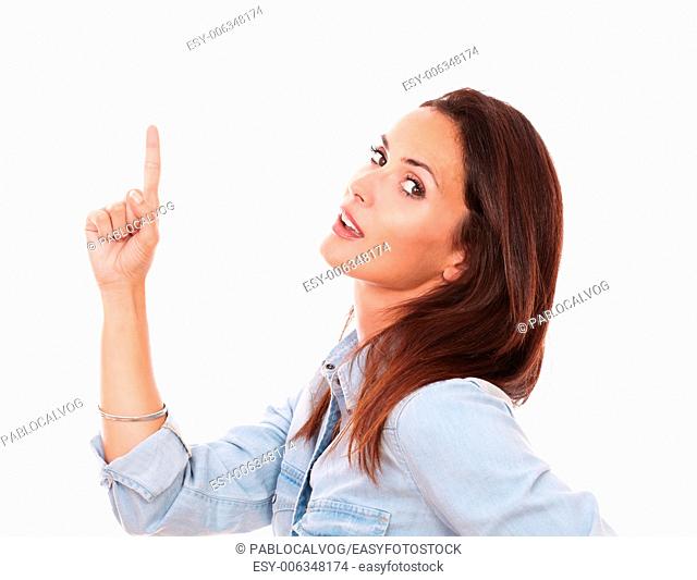 Portrait of attractive female on blue shirt pointing up and looking at you on isolated white background - copyspace