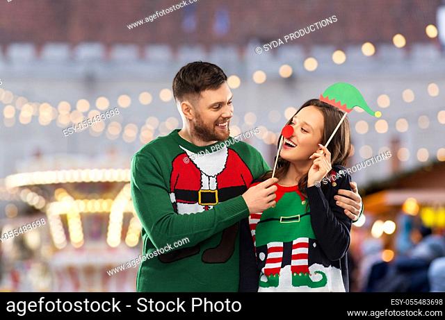 couple in sweaters with christmas party props