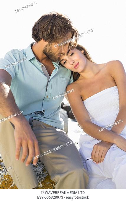 Gorgeous couple embracing at the coast on a sunny day