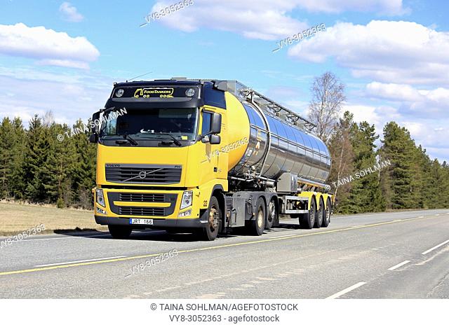 Yellow Volvo FH semi tanker for food transport on Highway 10 on a beautiful day of spring in Lieto, Finland - May 13, 2017