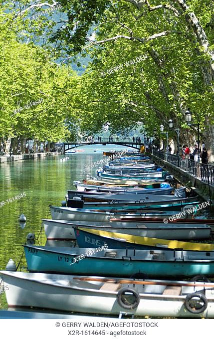 Rowing boats on the tree-lined Canal du VassÃ© in Annecy, France