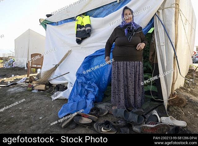 13 February 2023, Turkey, Ördekdede: Cemile Mitiler stands in front of a tent that serves as her emergency shelter. In the small village