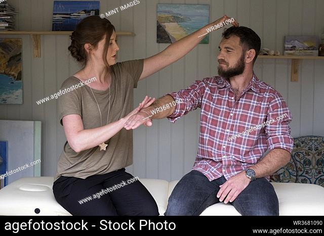 Alternative therapist and man during a consultation, using EFT tapping techniques therapy