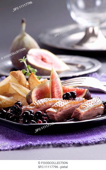 Duck breast with roast potatoes, figs and berry compote