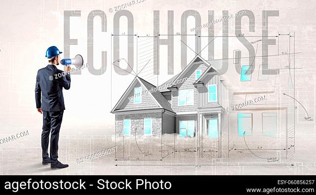 Young engineer holding blueprint with ECO HOUSE inscription, house planning concept