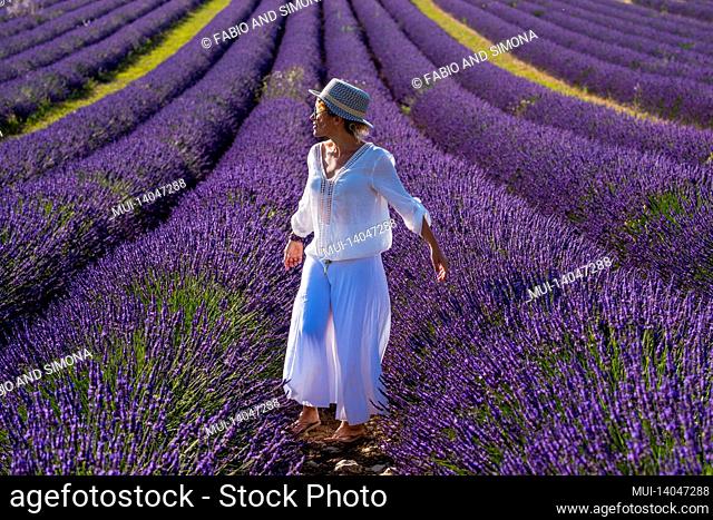 portrait of beautiful fashion woman in lavender fields visiting provence france for summer holiday vacation alone - concept of beauty and trendy travel people...