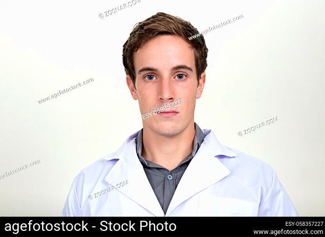 Studio shot of young handsome man doctor against white background