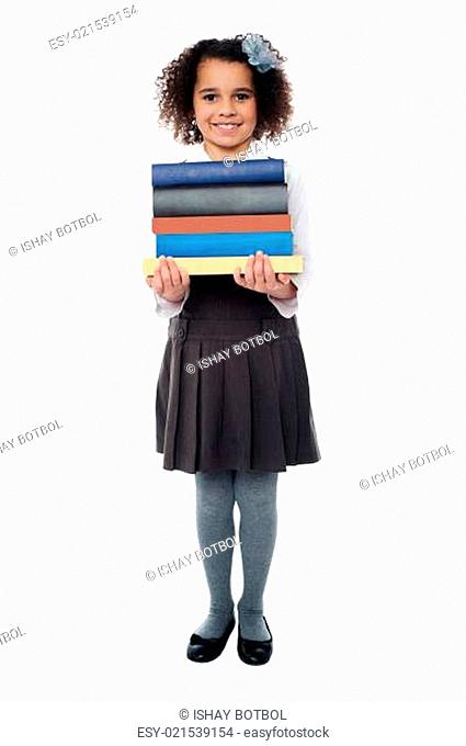 Active school child carrying stack of books