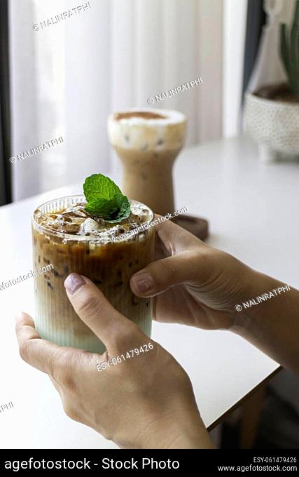 Hand on glass of iced coffee, stock photo