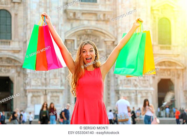 Shopping and tourism concept. Euphoric beautiful woman with shopping bags in city