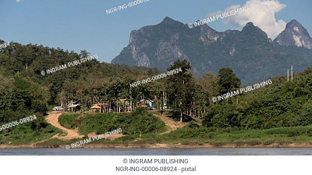 Shoreline village with rocky mountains in background, River Mekong, Pak Ou District, Luang Prabang, Laos