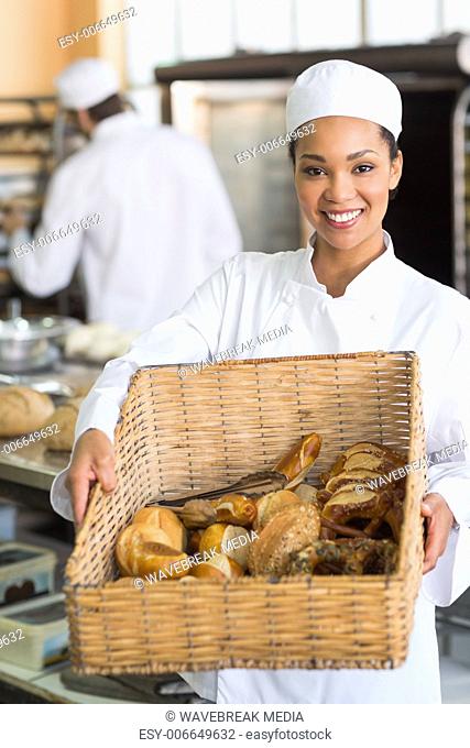 Pretty baker showing basket of bread
