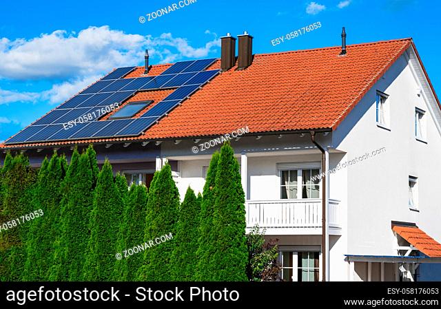 Generic modern house (modified by image editing) with photovoltaic solar cells on the roof for alternative energy production