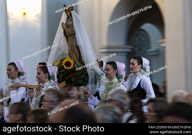 08 September 2022, Saxony, Rosenthal: Druzhkas, girls dressed in Sorbs' festive costumes, carry the parish's statue of the Virgin Mary in a procession to the...