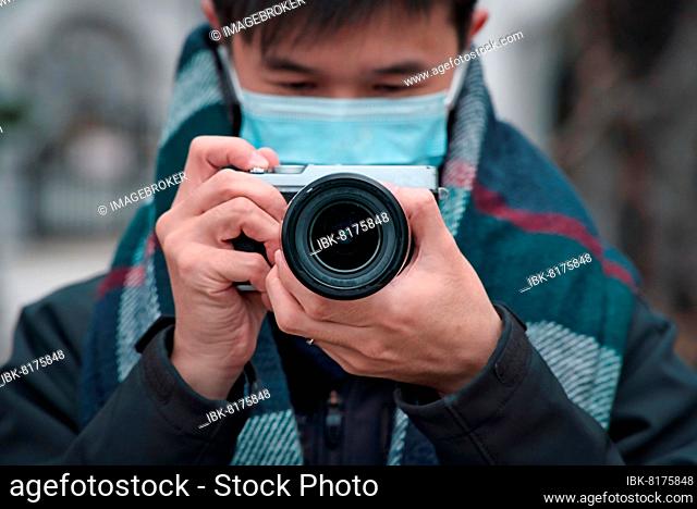 Man holding camera, taking photos, photographer, photography