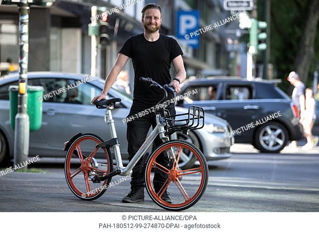 08 May 2018, Germany, Duessseldorf: Jimmy Cliff, head of Mobike Germany, stands on a sidewalk with a rental bike. The Chinese rental bike provider Mobike will...