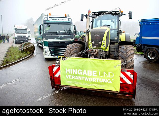 01 December 2020, Lower Saxony, Cloppenburg: A tractor, to which a banner with the inscription ""Dedication and Responsibility"" is attached