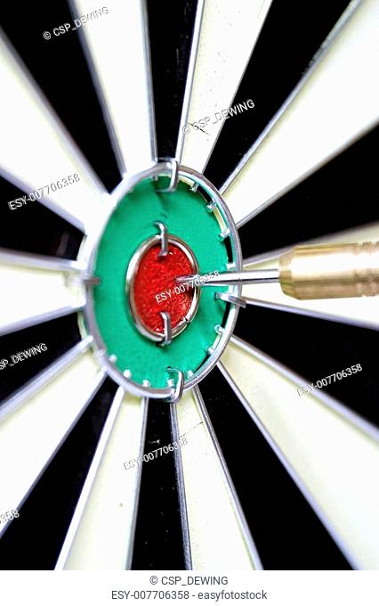 A stock photograph of a dart board with a dart hitting the bulls eye
