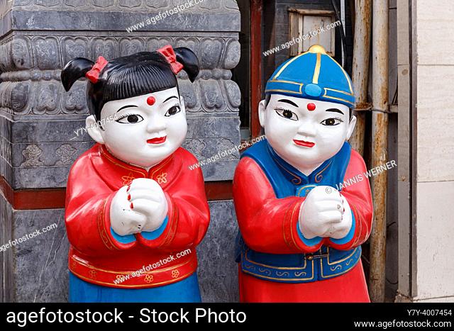 BEIJING, CHINA - MARCH 11, 2018. Figurines of a girl and a boy in traditional garb at a street market in Beijing, China on March 11, 2018