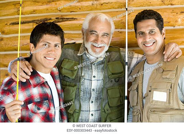 Middle-aged man with two sons holding fishing rods smiling portrait
