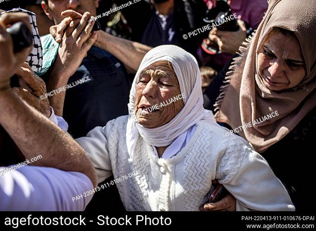 13 April 2022, Palestinian Territories, Kafr Laqif: Relatives mourn during the funeral of Palestinian Mohamed Assaf, who was shot dead earlier in the day by...