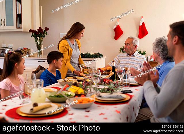Multi generation caucasian family sitting at table for dinner together