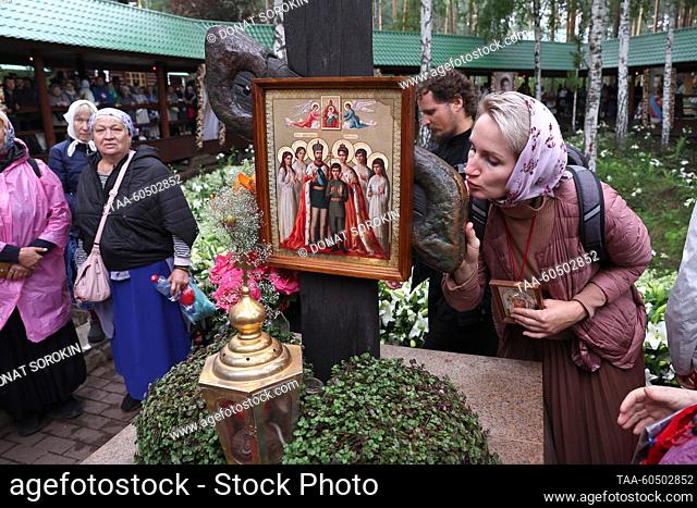RUSSIA, SVERDLOVSK REGION - JULY 17, 2023: Believers are seen by a memorial cross at the Holy Royal Passion-Bearers Monastery at Ganina Yama after a religious...