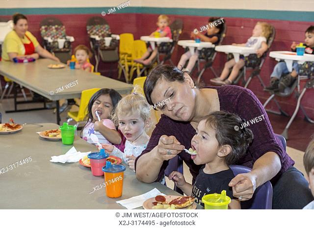 Alpine, Texas - Mari Rodrigez feeds a child during lunch at the Alpine Community Center. The Center is a mission project of United Methodist Women