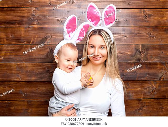 Easter concept. Happy mother and her cute child wearing bunny ears getting ready for Easter