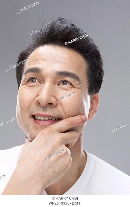 Middle aged man touching face