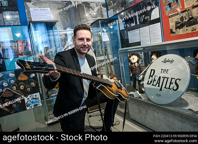 PRODUCTION - 07 April 2022, Saxony-Anhalt, Halle (Saale): Beatles Museum director Martin Schmidt shows a replica of Paul McCartney's 1962 bass guitar